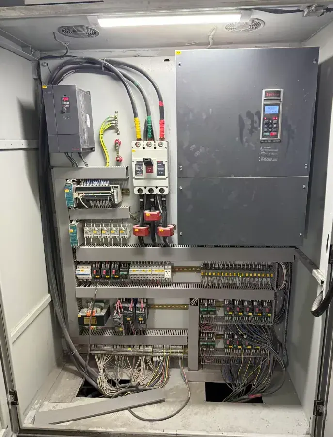 Interior del armario de control de la prensa: variador, PLC, borneras y relés