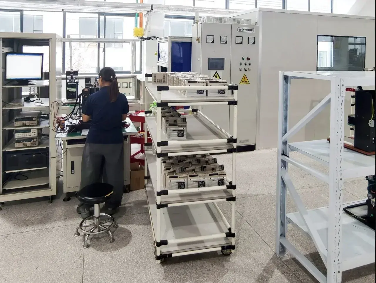 Variadores en bastidores de prueba con un técnico en la consola de monitoreo